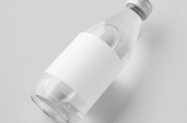 istock Small water bottle mockup with blank label, clear glass, closeup 2242795882