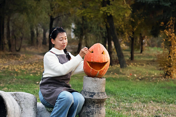 Young Asian girls making pumpkin lanterns