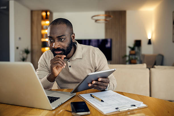 istock African american man working from home using laptop and tablet 2242801265