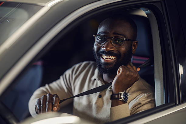 istock African man smiling, putting on seat belt in car 2242801368