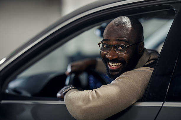 istock Happy black man driving car and smiling 2242801383