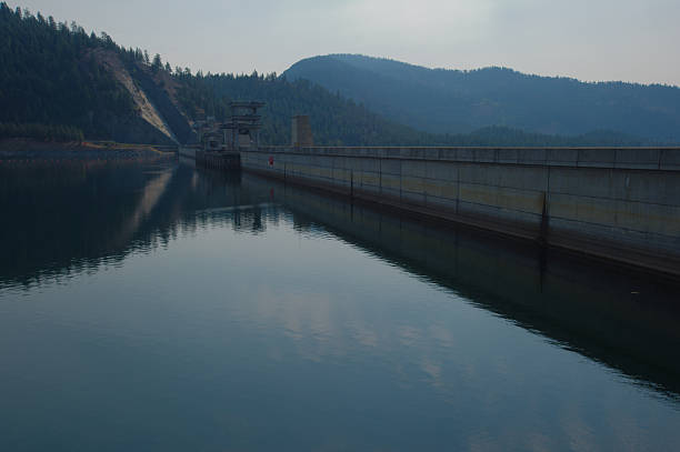 istock Serene Libby Dam With Calm Water, Mountain Range, And Rocky Shoreline At Riverside Park in Montana. 2242803348