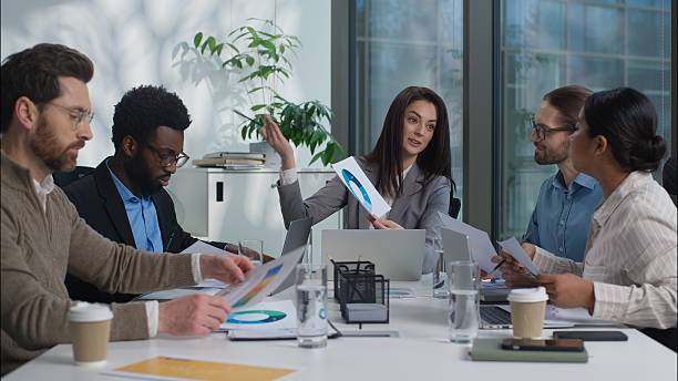 istock Multicultural business team talking discussing Caucasian leader presenting chart graph African American Indian men women together planning workers analyzing statistic project in office businesspeople 2242805137