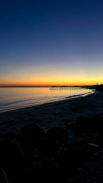 istock Evening Light on the Beach with Pier and Lighthouse 2242805343