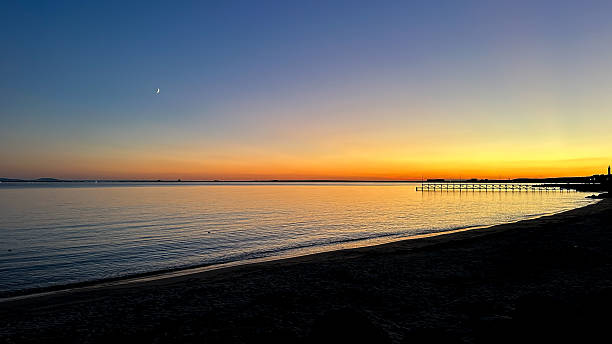 istock Twilight Seascape with Crescent Moon and Orange Horizon 2242805370