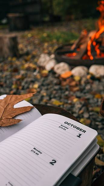 istock October 1st in a journal with a fall leaf and a cozy campfire in the background 2242807274
