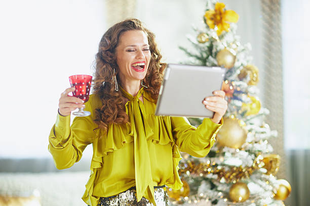 istock Festive Woman Laughing on Video Call by Christmas Tree 2242809269