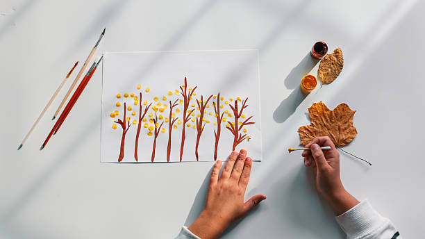 istock Child's Autumn Art Project with Paint and Leaves 2242811847