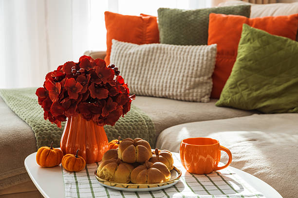istock Autumn Living Room with Sofa, Pillows and Pumpkin Cinnamon Buns on Coffee Table 2242811916