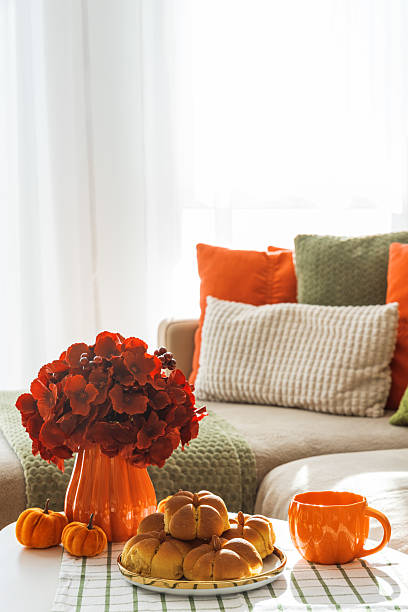 istock Autumn Living Room with Sofa, Pillows and Pumpkin Cinnamon Buns on Coffee Table 2242811924
