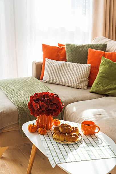 istock Autumn Living Room with Sofa, Pillows and Pumpkin Cinnamon Buns on Coffee Table 2242811950