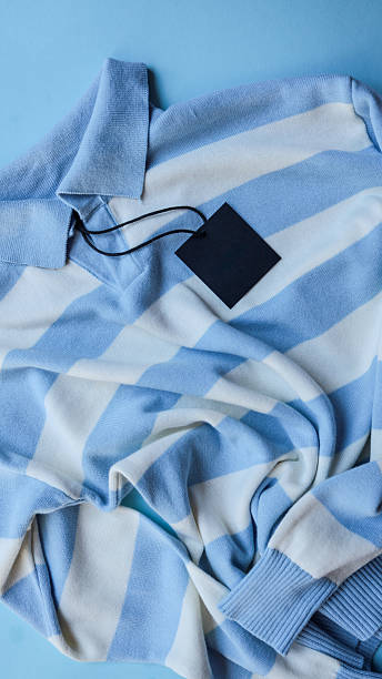 istock Blue and white striped sweater with a blank tag on a blue background. 2242815264