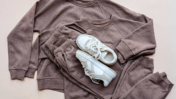 Stylish loungewear set with sneakers on a neutral background.