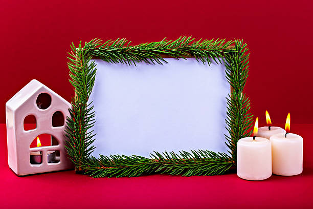 istock Festive holiday frame decorated with pine branches, candles and small decorative house 2242816591