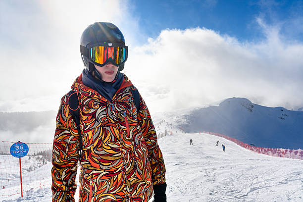 A female skier on the snowy slopes, surrounded by the majestic mountain landscape and bright winter sun, ready to hit the slopes again.