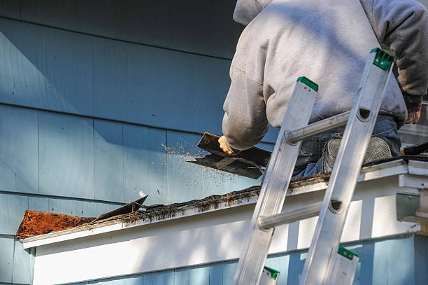 istock worker removing old shingle on the roof for renovation 2242818932