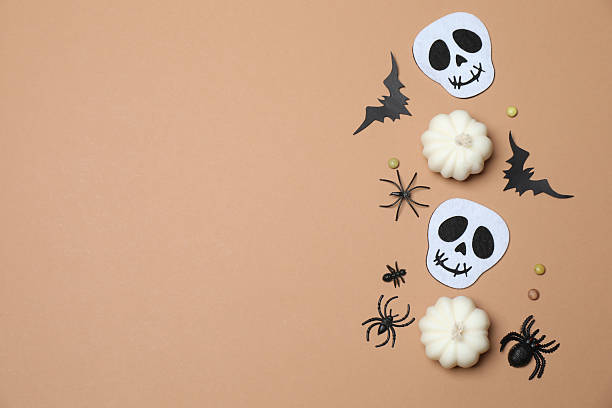 istock Elegant Halloween decor. Top view capturing thematic elements: small orange and golden pumpkins, insects, scary spiders, cobwebs, bats. Empty space for greetings or promotions. 2242819498