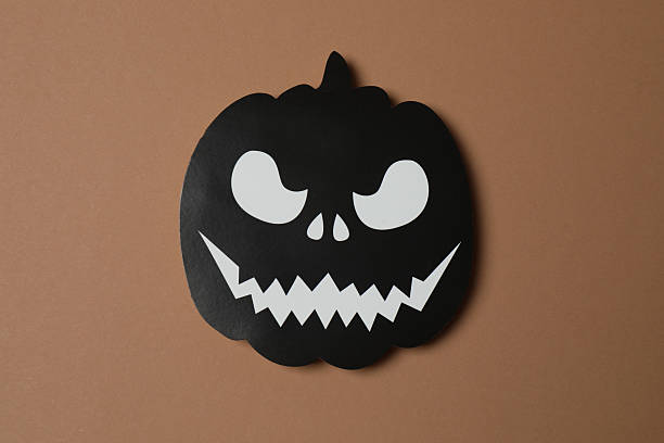 Elegant Halloween decor. Top view capturing thematic elements: small orange and golden pumpkins, insects, scary spiders, cobwebs, bats. Empty space for greetings or promotions.