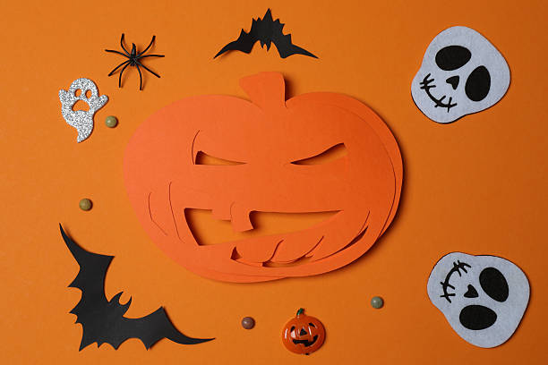 istock Elegant Halloween decor. Top view capturing thematic elements: small orange and golden pumpkins, insects, scary spiders, cobwebs, bats. Empty space for greetings or promotions. 2242819554
