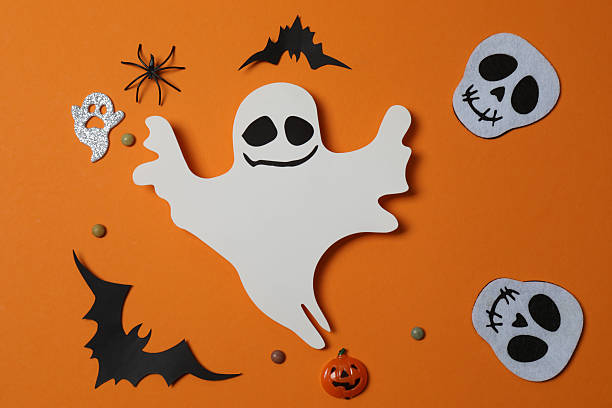 istock Elegant Halloween decor. Top view capturing thematic elements: small orange and golden pumpkins, insects, scary spiders, cobwebs, bats. Empty space for greetings or promotions. 2242819565