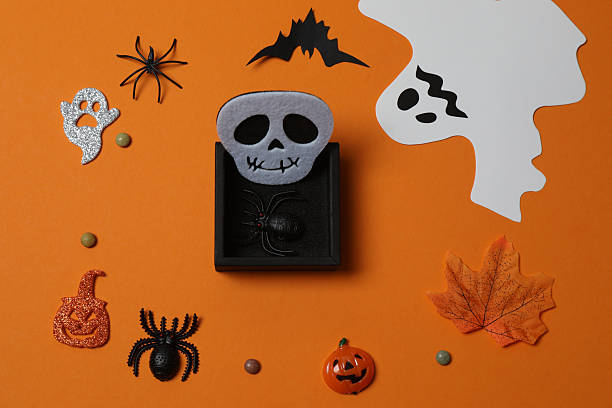 istock Elegant Halloween decor. Top view capturing thematic elements: small orange and golden pumpkins, insects, scary spiders, cobwebs, bats. Empty space for greetings or promotions. 2242819580