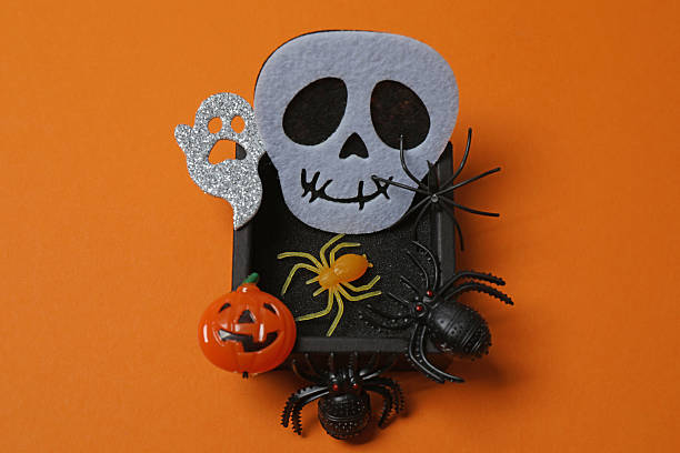 istock Elegant Halloween decor. Top view capturing thematic elements: small orange and golden pumpkins, insects, scary spiders, cobwebs, bats. Empty space for greetings or promotions. 2242819587