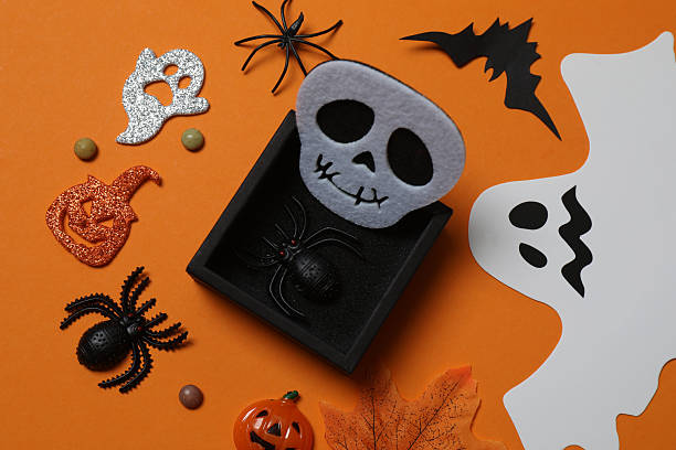 istock Elegant Halloween decor. Top view capturing thematic elements: small orange and golden pumpkins, insects, scary spiders, cobwebs, bats. Empty space for greetings or promotions. 2242819589