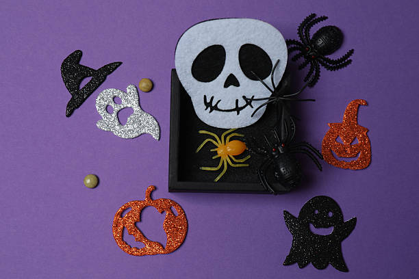 istock Elegant Halloween decor. Top view capturing thematic elements: small orange and golden pumpkins, insects, scary spiders, cobwebs, bats. Empty space for greetings or promotions. 2242820126