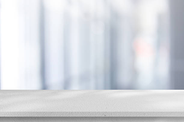 istock Abstract blurred interior modern office room background with perspective white cement table for show, promote and design content or product on display concept 2242822599