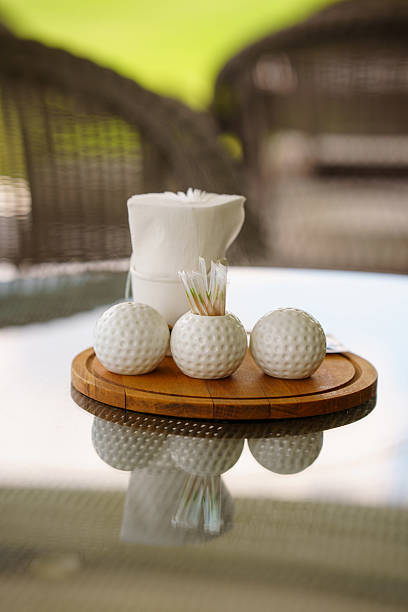 istock Golf accessories on a wooden tray at a sunny patio 2242834476