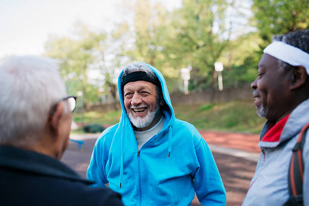Diverse senior men laughing while exercising outdoors, sharing a joyful moment