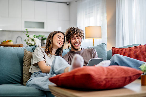 istock Young couple laughing relaxing at home using tablet 2242837088