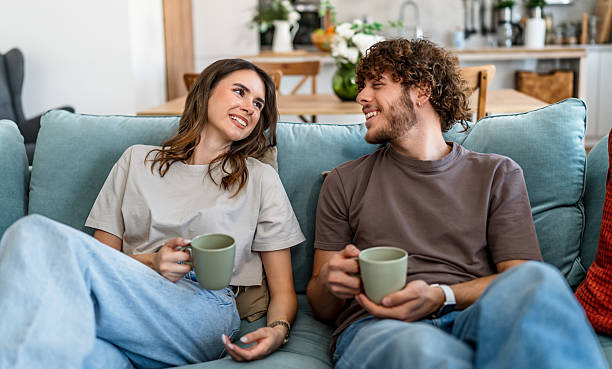 istock Young couple relaxing together on sofa at home 2242838584