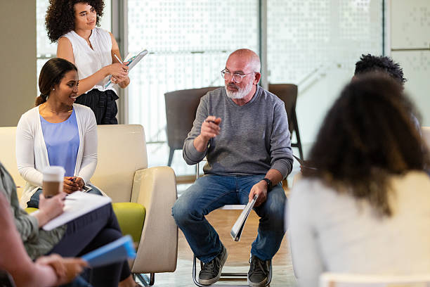 istock Diverse group participating in a support session with a mental health professional leading. 2242840121
