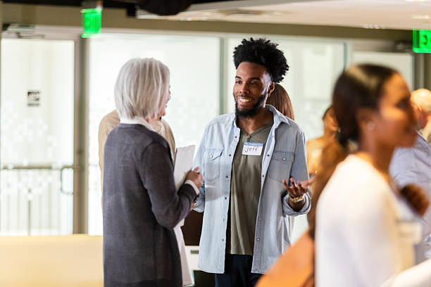 istock Diverse group of people conversing and networking at an indoor event. 2242840172