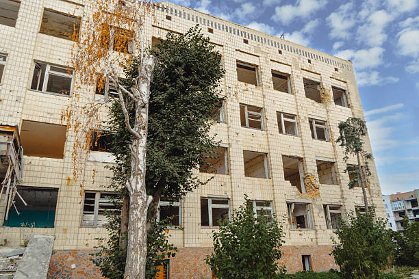 istock Heavily damaged apartment building with many destroyed windows after a war 2242845637