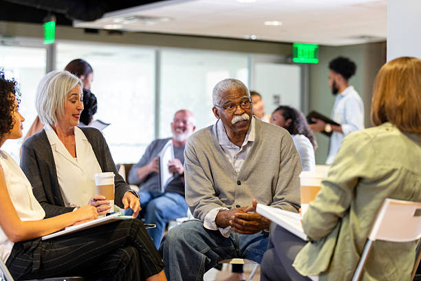 istock Diverse group of adults engaged in conversation and learning during a meeting 2242845852