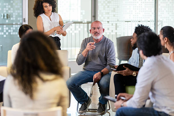 istock Group therapy session fosters communication and emotional support among diverse participants in a modern setting. 2242848367
