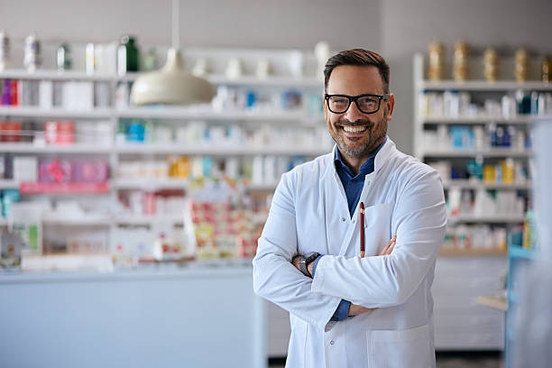 istock Happy pharmacist with arms crossed in a pharmacy looking at camera. 2242851230