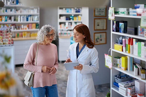 istock Happy pharmacist and senior woman using digital tablet in a pharmacy. 2242851231
