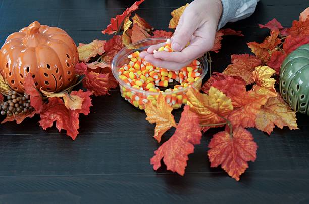 istock Man Eating Candy Corn for in Fall - Pumpkin and Leave Decor 2242852518