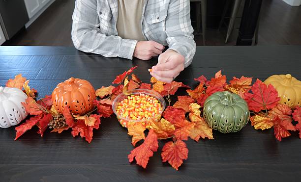 istock Man Eating Candy Corn for in Fall - Pumpkin and Leave Decor 2242852519