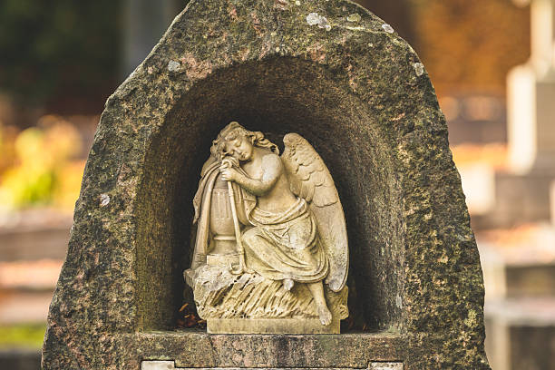 Angel sculpture resting in stone alcove at old cemetery.