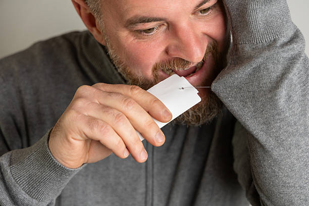 istock Man examining clothing tag while wearing cozy sweater in indoor setting. copy space 2242854556