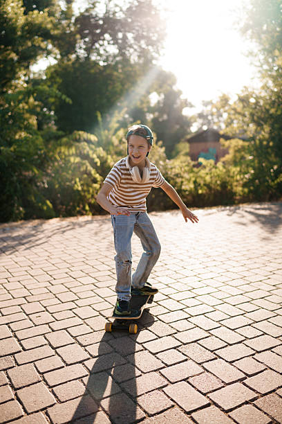 Young boy enjoying skateboarding in a park, feeling joy and freedom.
