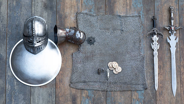 istock Medieval chainmail, sword and shield on a wooden background 2242859669