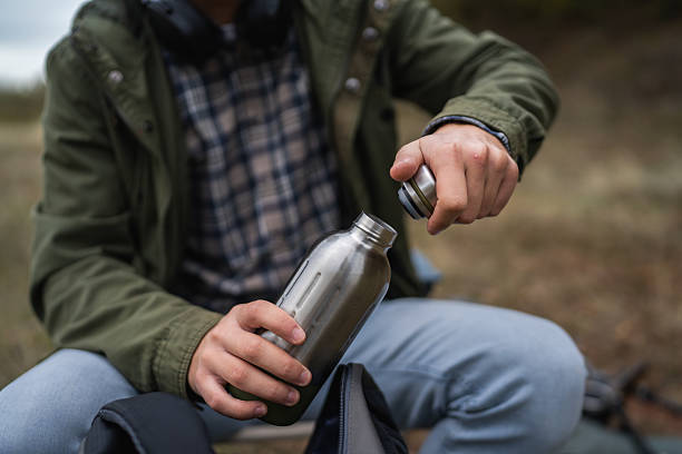 istock Man holding reusable water bottle during outdoor hike 2242861123