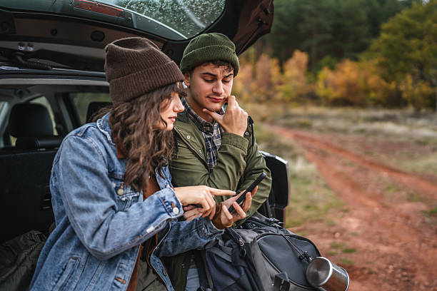 istock Couple planning road trip using smart phone navigation in autumn forest 2242861126