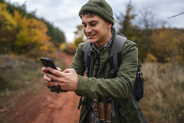 istock Young man hiking using smart phone in autumn nature 2242861172