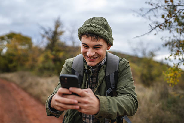 istock Young man hiking using smart phone in autumn nature 2242861220